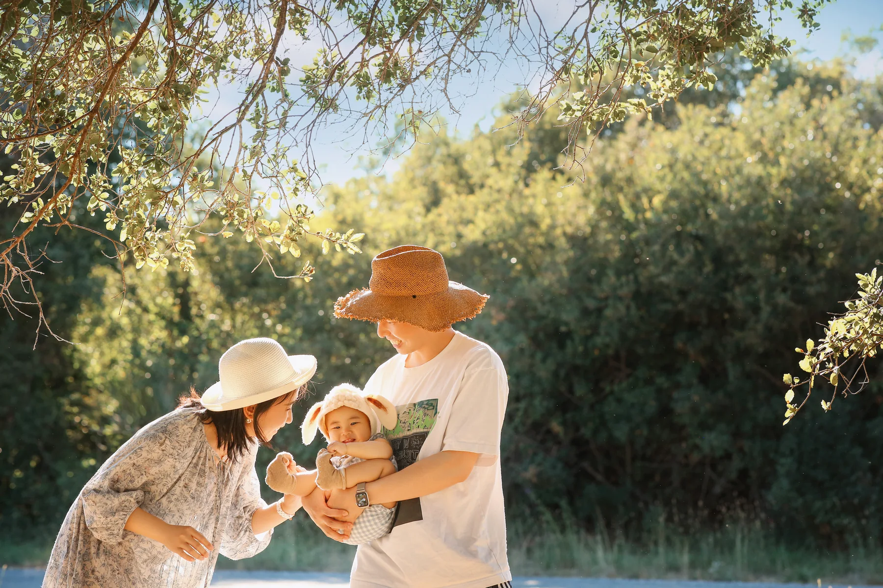 Family sharing a moment outdoors beneath the trees